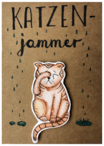 Comicartige Zeichnung einer Katze, die weint und eine Pfote über ihr Auge legt; 
          darüber ist der Schriftzug 'Katzenjammer' sowie Illustrationen von Tränen, die herunterfallen und sich am unteren Bildrand in drei kleinen Pfützen sammeln